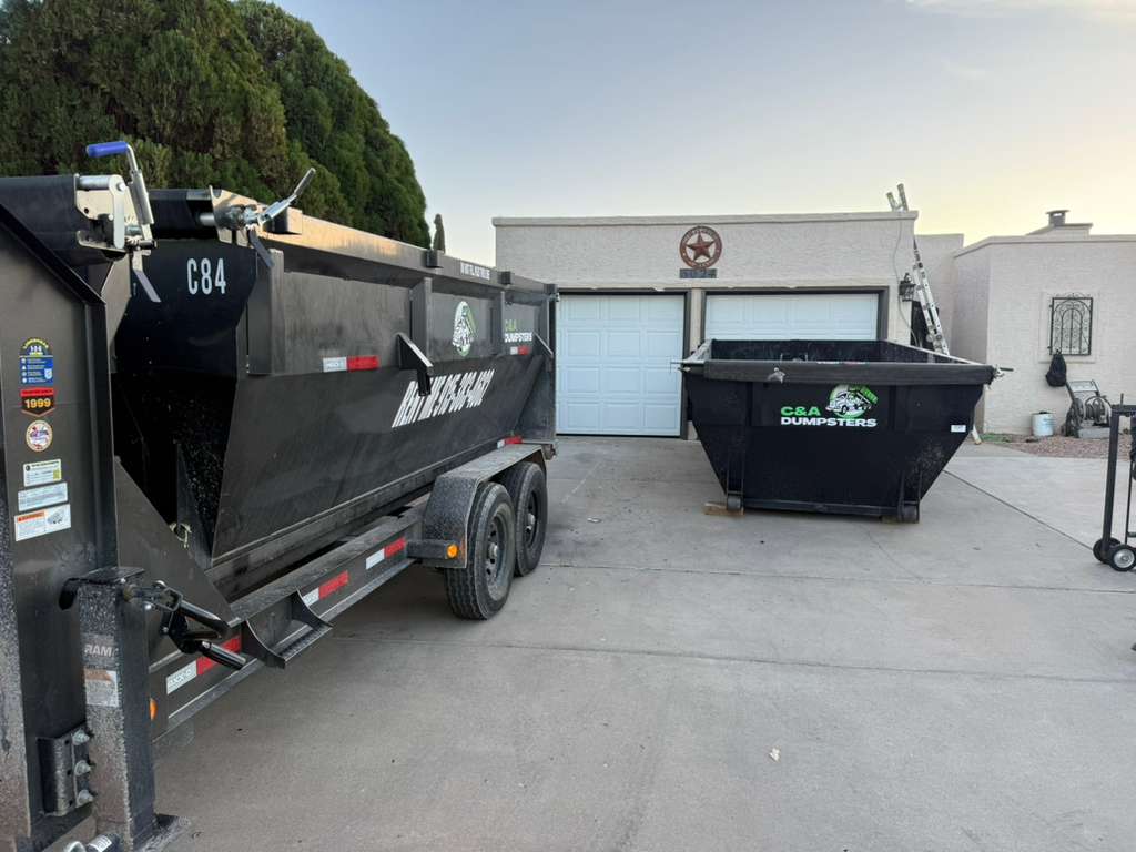Multiple dumpsters positioned in a wide residential driveway